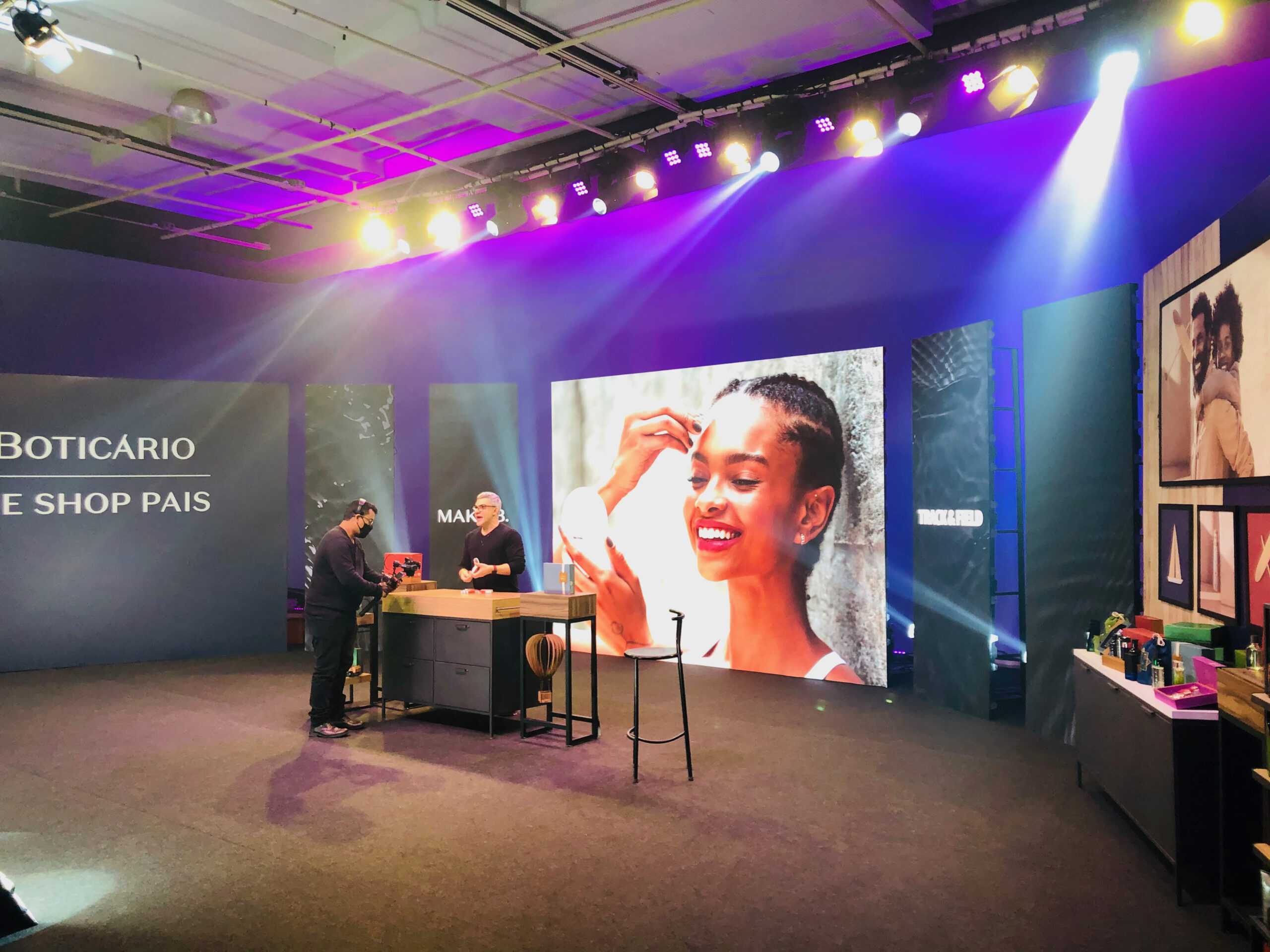 Montagem de Palco para Talk Show e Branding de Varejo (Boticário) – Upgrade Rental Palco de evento de marca (O Boticário) montado para talk show/entrevista com painel de LED vertical e iluminação cênica de destaque.